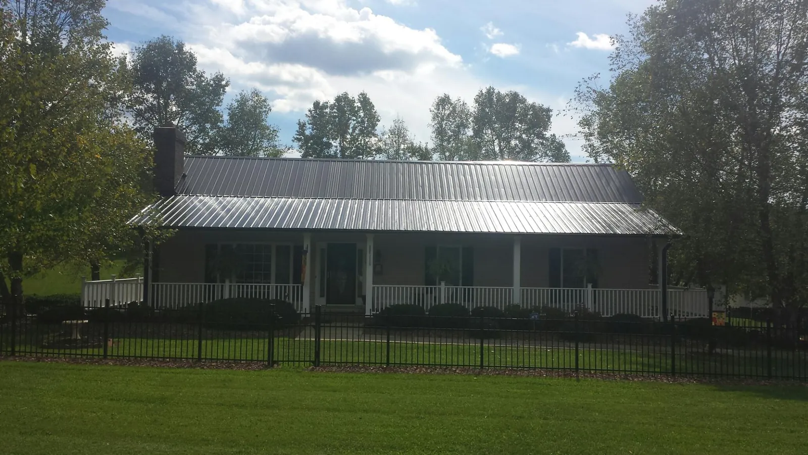 Gray metal roof on a brick ranch with a full width front porch — Gutter Guard Installation work by our crew in Grandview